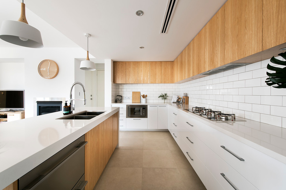 Medium sized modern kitchen in Perth with a submerged sink, engineered stone countertops, white splashback, metro tiled splashback, stainless steel appliances, porcelain flooring and an island.