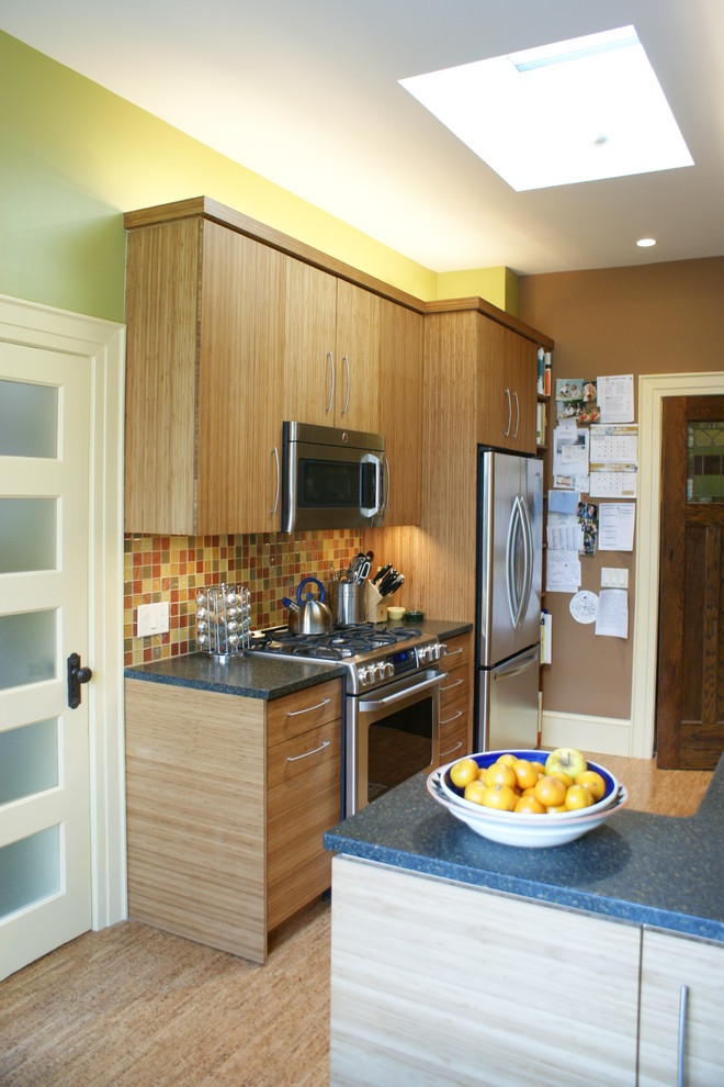 Cette photo montre une cuisine chic en bois brun avec un électroménager en acier inoxydable, un placard à porte plane, une crédence multicolore et une crédence en mosaïque.