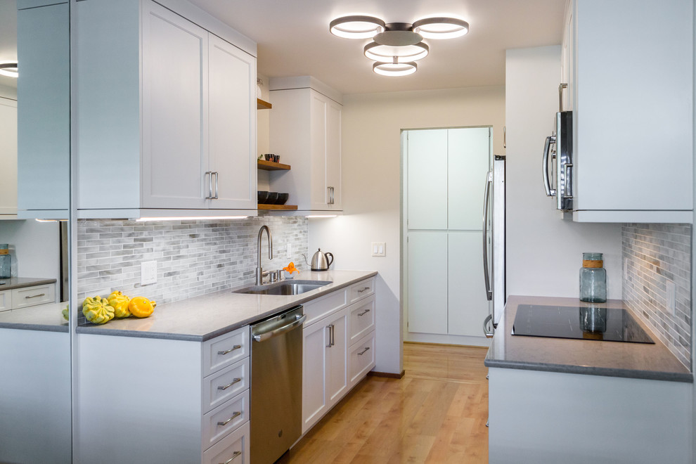 Small transitional galley laminate floor and brown floor eat-in kitchen photo in San Francisco with an undermount sink, shaker cabinets, white cabinets, solid surface countertops, multicolored backsplash, glass tile backsplash, stainless steel appliances, no island and gray countertops
