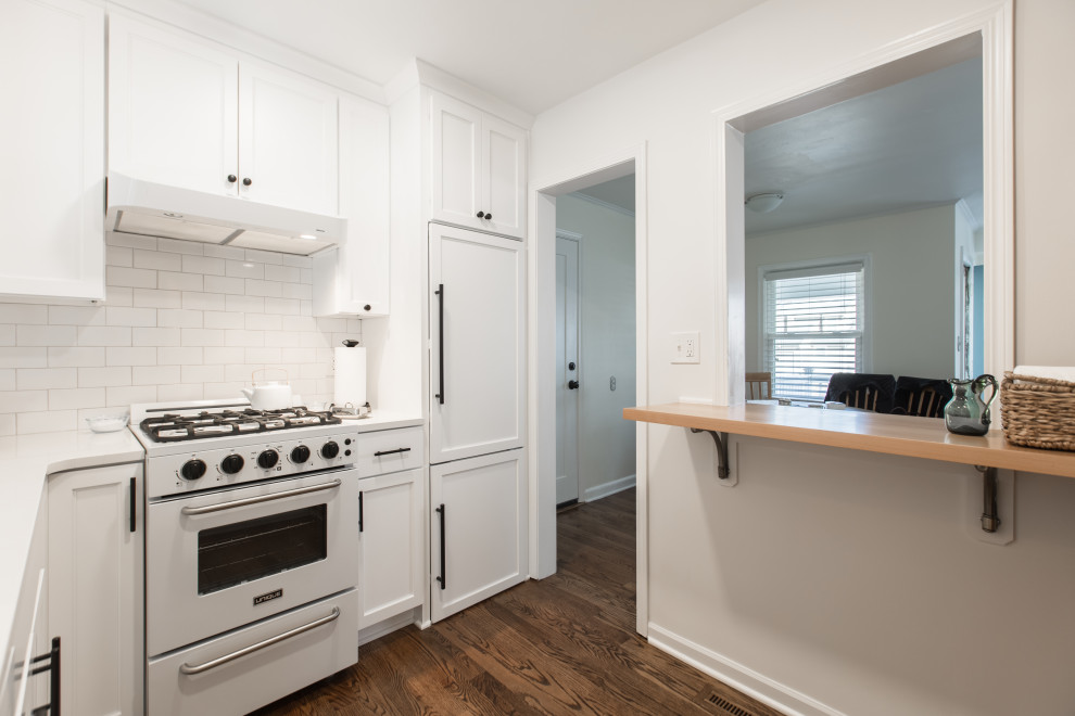 Kitchen - small transitional l-shaped medium tone wood floor and brown floor kitchen idea in Kansas City with an undermount sink, shaker cabinets, white cabinets, quartz countertops, white backsplash, subway tile backsplash, paneled appliances and white countertops