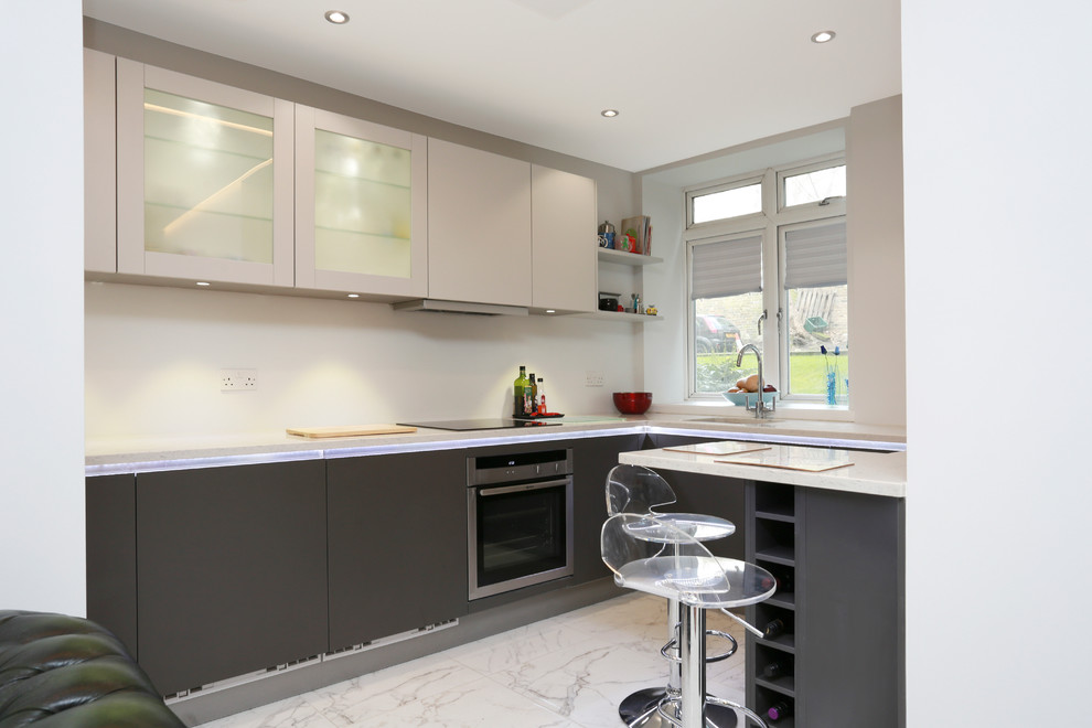 Foto de cocina minimalista pequeña con armarios con paneles lisos, puertas de armario grises y electrodomésticos de acero inoxidable