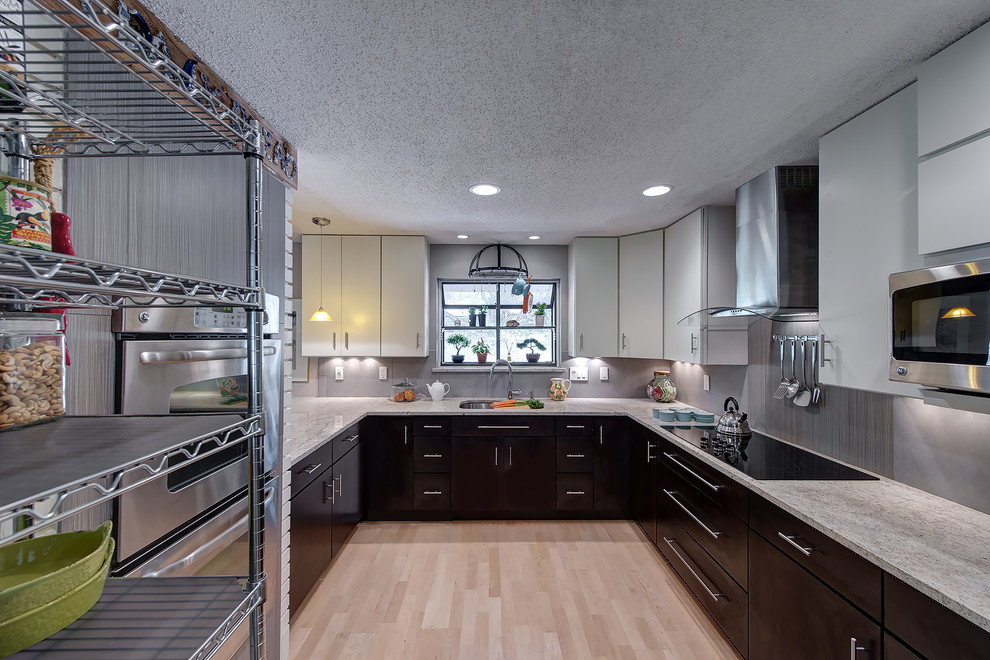 Geschlossene Moderne Küche in U-Form mit flächenbündigen Schrankfronten, grauen Schränken, Küchengeräten aus Edelstahl und Küchenrückwand in Grau in St. Louis