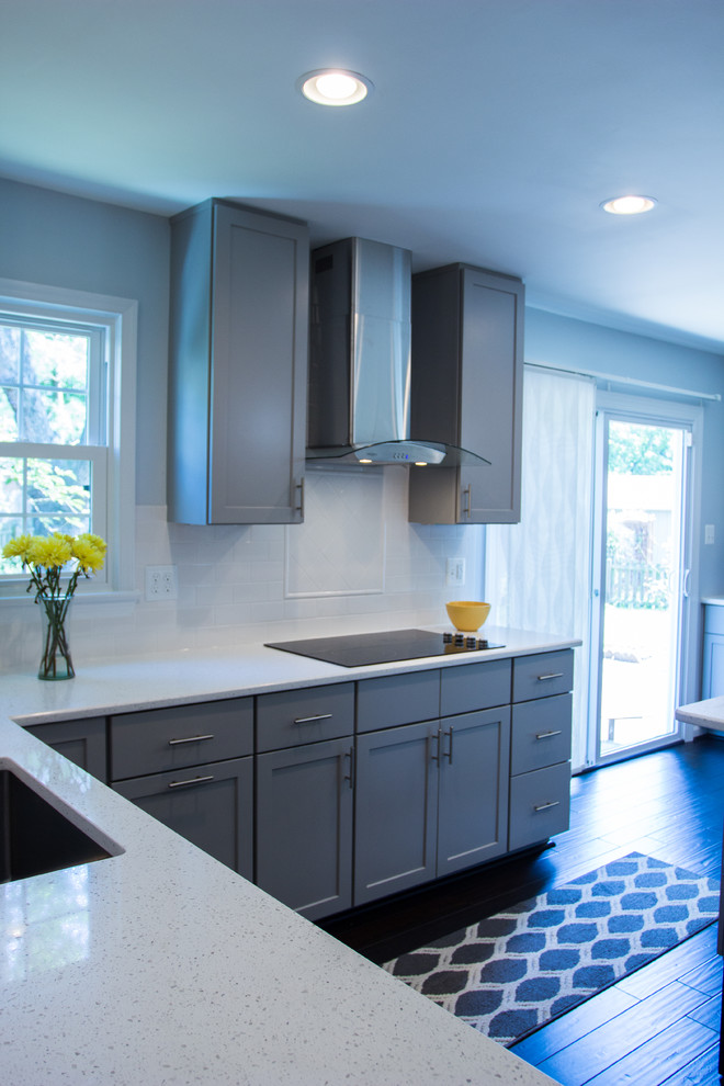 Bild på ett litet funkis kök, med en undermonterad diskho, skåp i shakerstil, grå skåp, granitbänkskiva, vitt stänkskydd, stänkskydd i keramik, rostfria vitvaror, mörkt trägolv och en köksö