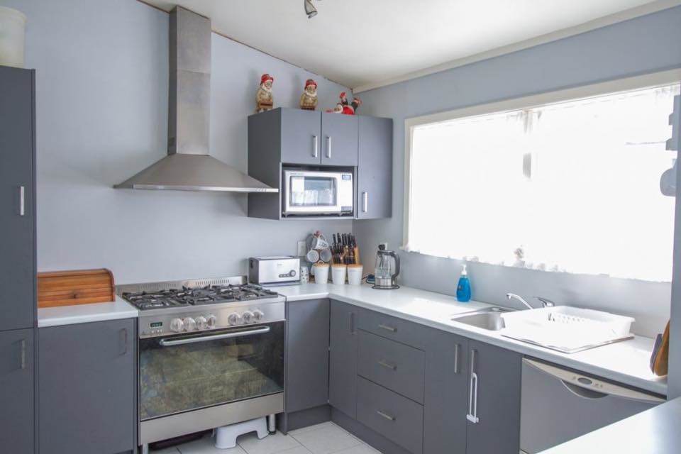 Photo of a small modern u-shaped kitchen/diner in Hamilton with a single-bowl sink, grey cabinets, laminate countertops, stainless steel appliances, ceramic flooring and an island.