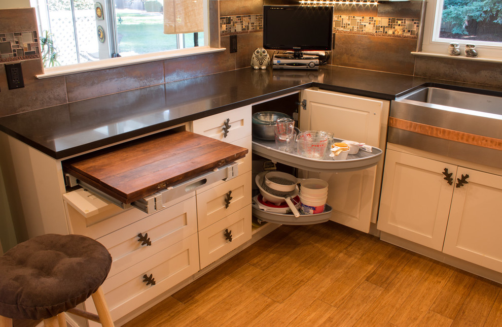 Photo of a small eclectic u-shaped enclosed kitchen in San Francisco with a belfast sink, shaker cabinets, beige cabinets, quartz worktops, metallic splashback, glass tiled splashback, stainless steel appliances, bamboo flooring and no island.