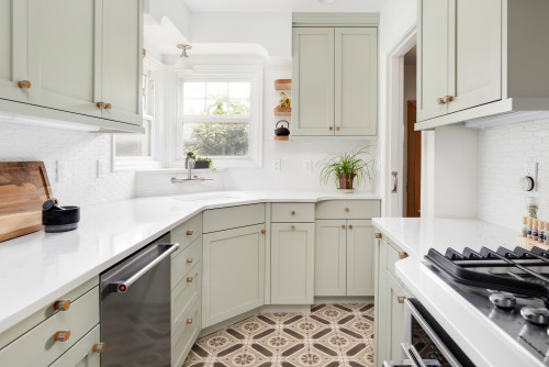 Galley kitchen with sage green cabinets.
