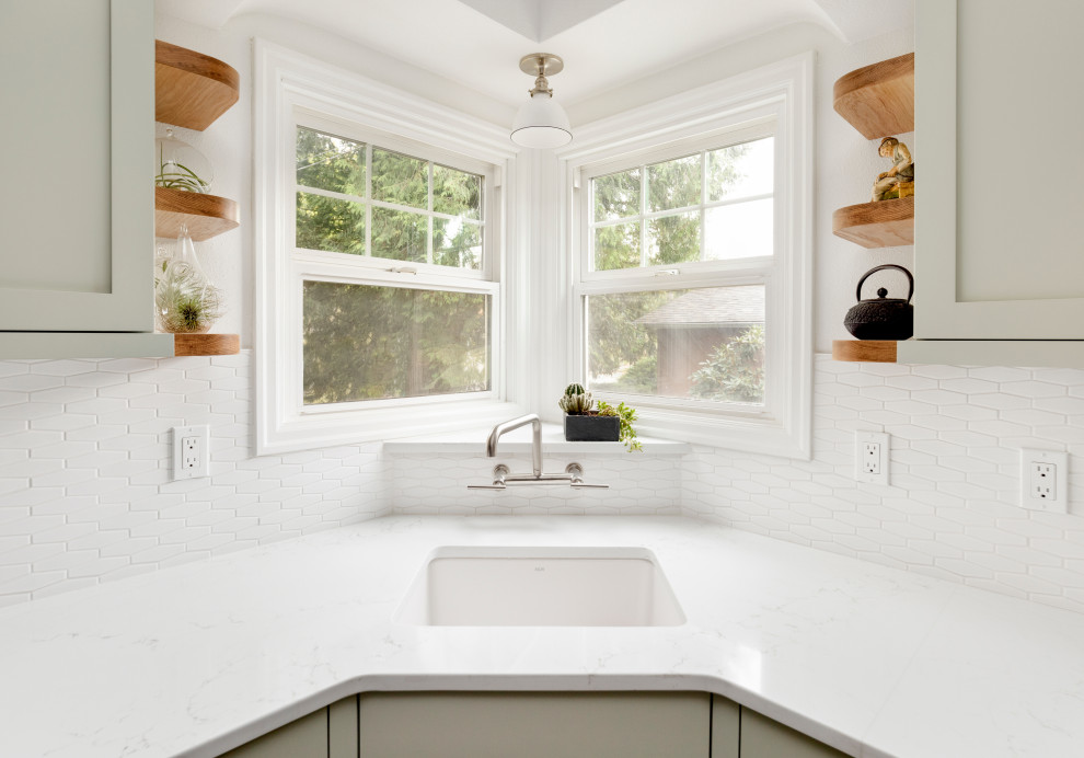Exempel på ett litet, avskilt klassiskt vit vitt kök, med en undermonterad diskho, skåp i shakerstil, gröna skåp, bänkskiva i kvarts, vitt stänkskydd, stänkskydd i keramik, rostfria vitvaror, cementgolv och brunt golv