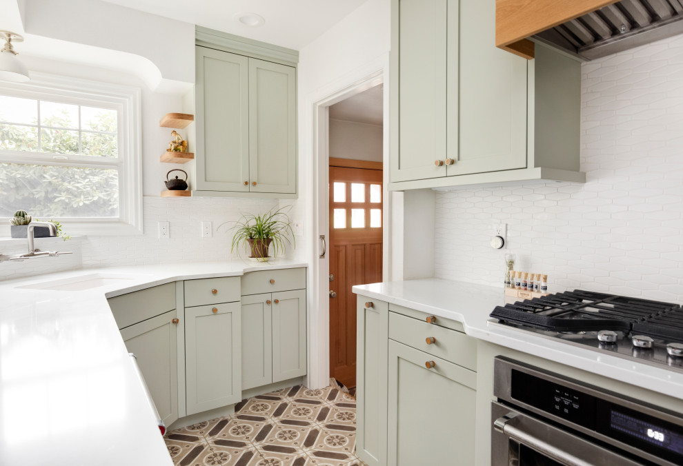 Inspiration for a small transitional cement tile floor and brown floor enclosed kitchen remodel in Portland with an undermount sink, shaker cabinets, green cabinets, quartz countertops, white backsplash, ceramic backsplash, stainless steel appliances and white countertops