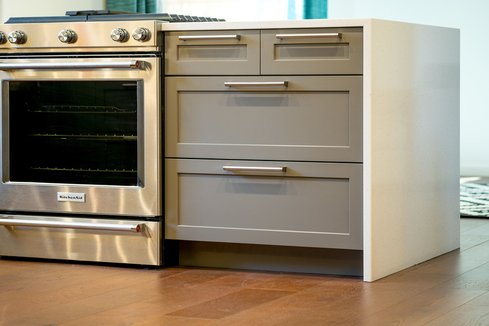 Inspiration for a mid-sized contemporary u-shaped dark wood floor kitchen remodel in Portland with an undermount sink, recessed-panel cabinets, gray cabinets, quartz countertops, white backsplash, glass tile backsplash, stainless steel appliances and a peninsula