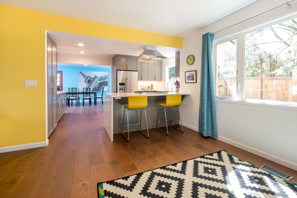 Inspiration for a mid-sized contemporary u-shaped dark wood floor kitchen remodel in Portland with an undermount sink, recessed-panel cabinets, gray cabinets, quartz countertops, white backsplash, glass tile backsplash, stainless steel appliances and a peninsula