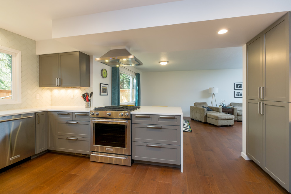 Kitchen - mid-sized contemporary u-shaped dark wood floor kitchen idea in Portland with an undermount sink, recessed-panel cabinets, gray cabinets, quartz countertops, white backsplash, glass tile backsplash, stainless steel appliances and a peninsula