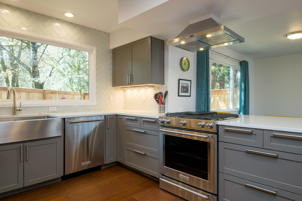 Kitchen - mid-sized contemporary u-shaped dark wood floor kitchen idea in Portland with an undermount sink, recessed-panel cabinets, gray cabinets, quartz countertops, white backsplash, glass tile backsplash, stainless steel appliances and a peninsula
