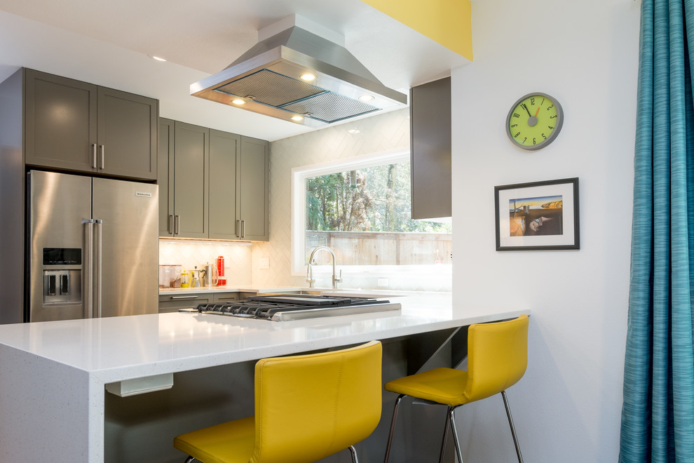 Example of a mid-sized trendy u-shaped dark wood floor kitchen design in Portland with an undermount sink, recessed-panel cabinets, gray cabinets, quartz countertops, white backsplash, glass tile backsplash, stainless steel appliances and a peninsula