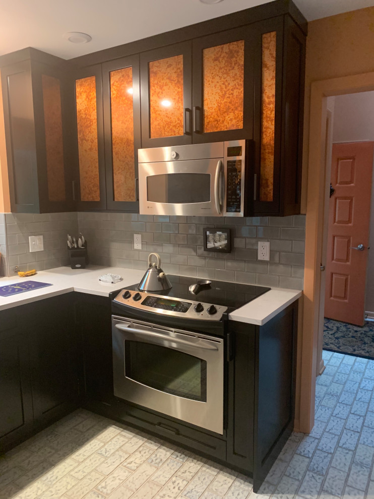 Idéer för avskilda, små vintage grått u-kök, med en dubbel diskho, luckor med infälld panel, svarta skåp, bänkskiva i kvarts, grått stänkskydd, stänkskydd i keramik, rostfria vitvaror, klinkergolv i keramik, en halv köksö och flerfärgat golv