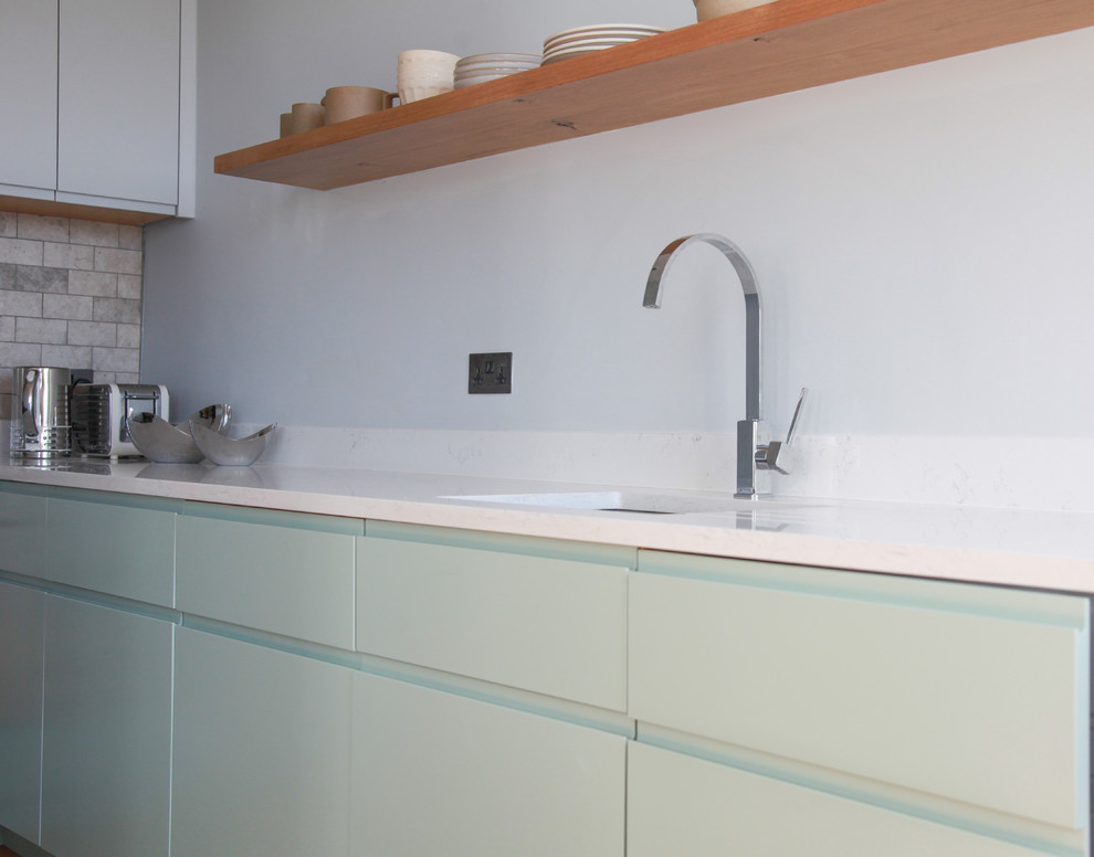 Esempio di una piccola cucina a L design chiusa con ante lisce, ante verdi, pavimento in legno massello medio e pavimento marrone