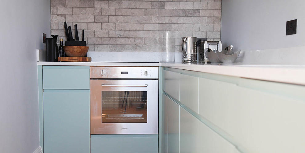 Ispirazione per una piccola cucina a L design chiusa con ante lisce, ante verdi, pavimento in legno massello medio e pavimento marrone