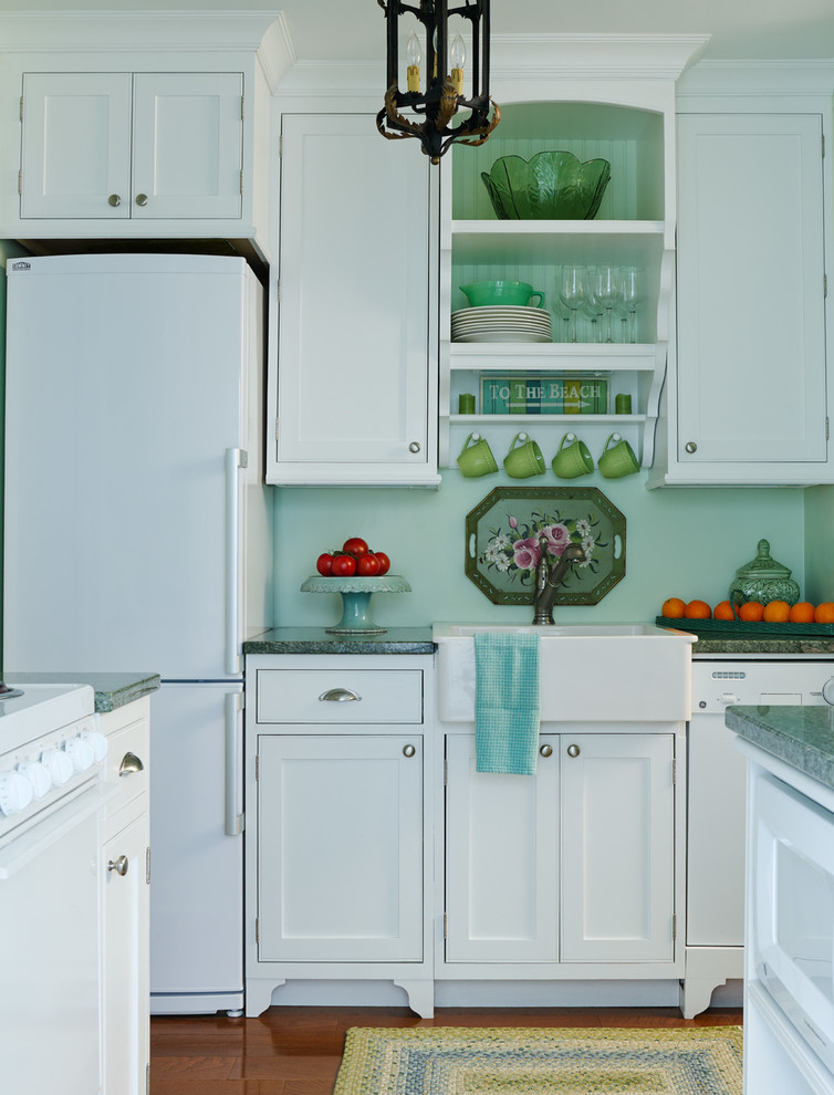 Beach style medium tone wood floor kitchen photo in Chicago with a farmhouse sink, shaker cabinets, white cabinets, white appliances and two islands