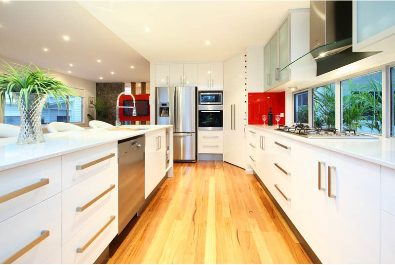 This is an example of a large modern galley kitchen/diner in Brisbane with a double-bowl sink, medium hardwood flooring and an island.