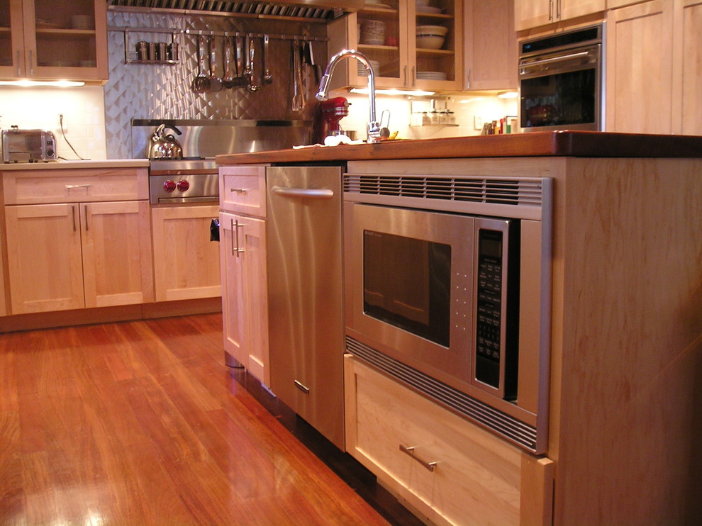 Exempel på ett avskilt, stort klassiskt l-kök, med en undermonterad diskho, luckor med infälld panel, skåp i ljust trä, träbänkskiva, rostfria vitvaror, mörkt trägolv, en köksö och brunt golv
