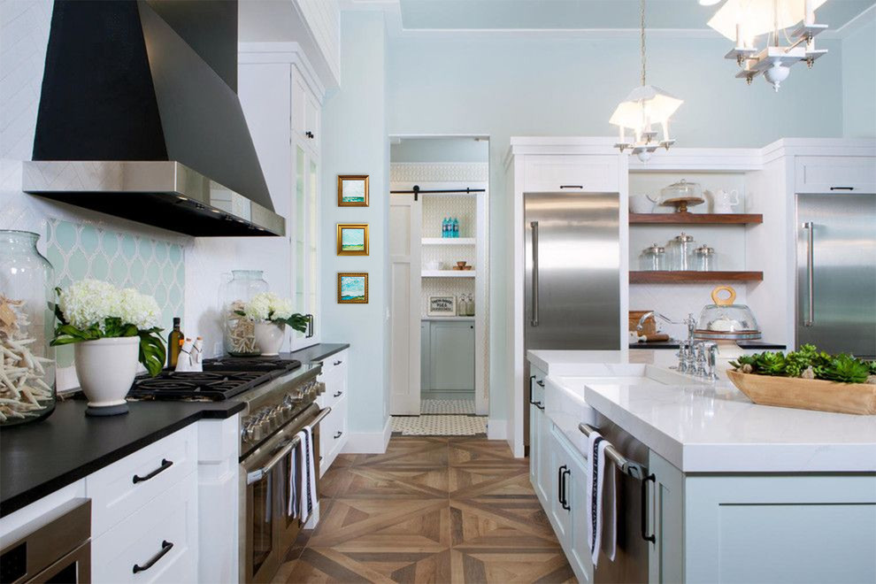 Design ideas for a large traditional l-shaped open plan kitchen in Charleston with a built-in sink, flat-panel cabinets, turquoise cabinets, engineered stone countertops, white splashback, ceramic splashback, stainless steel appliances, medium hardwood flooring, an island, brown floors and white worktops.