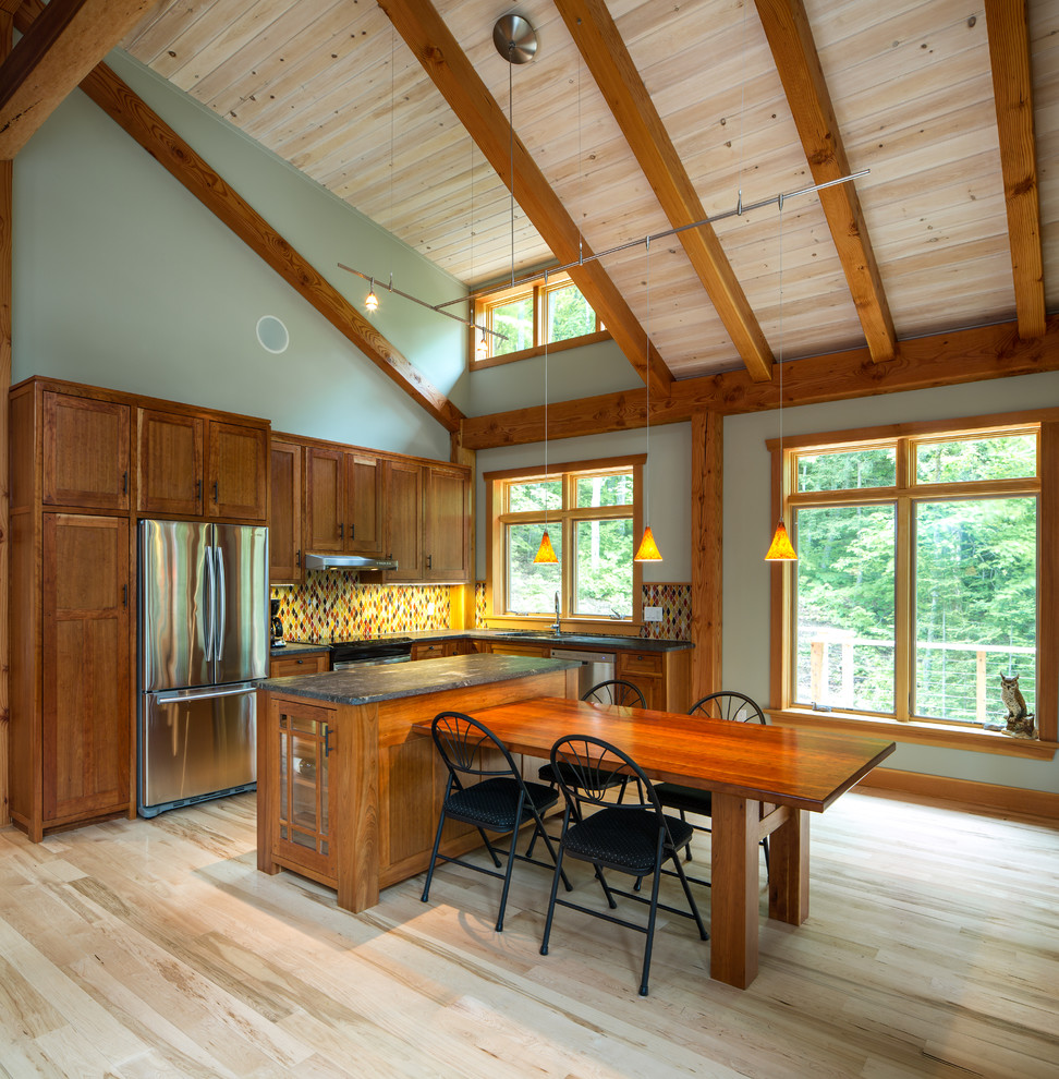 Eat-in kitchen - small rustic l-shaped light wood floor eat-in kitchen idea in Ottawa with an island, shaker cabinets, granite countertops, multicolored backsplash, glass tile backsplash, stainless steel appliances, an undermount sink and medium tone wood cabinets