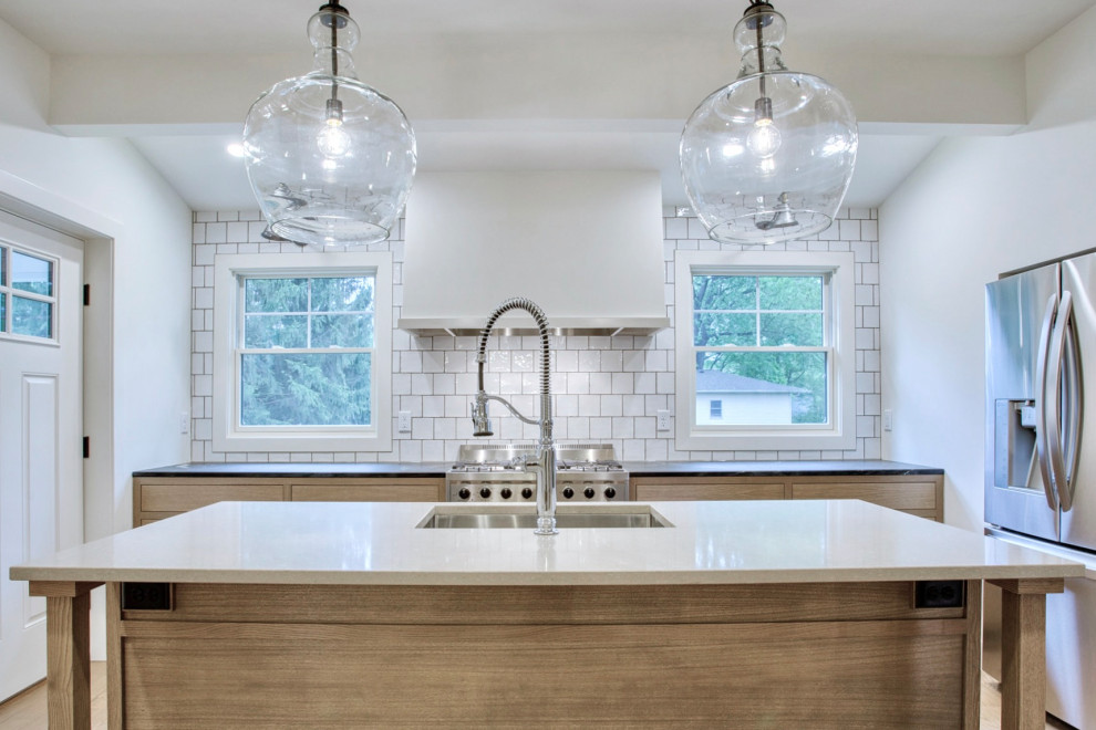 Inspiration for a mid-sized farmhouse single-wall light wood floor and beige floor enclosed kitchen remodel in Chicago with an undermount sink, light wood cabinets, quartz countertops, white backsplash, stainless steel appliances, an island, shaker cabinets, porcelain backsplash and white countertops