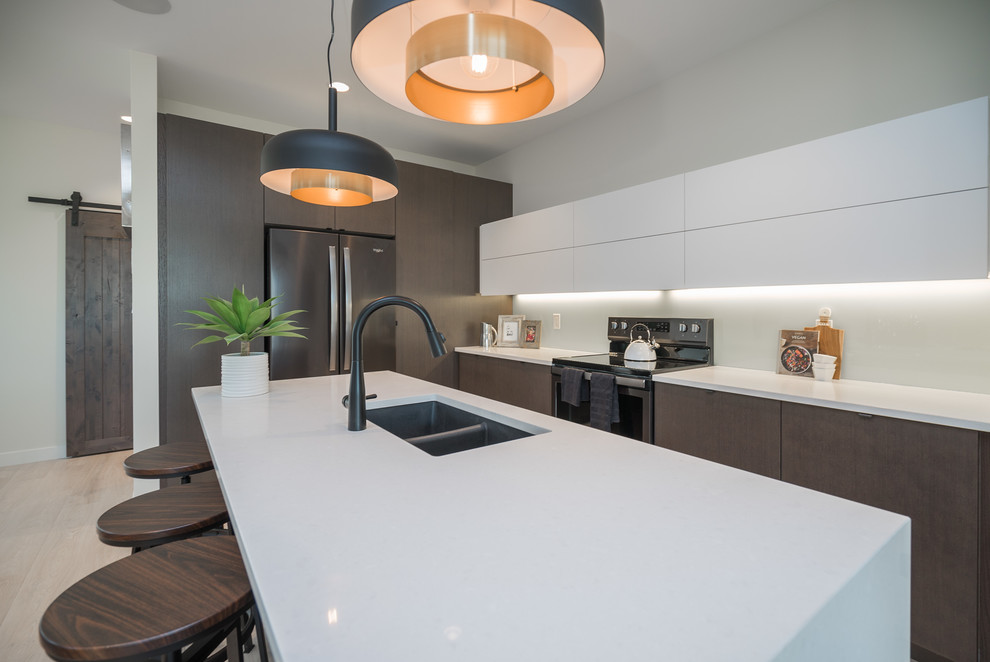 Mid-sized minimalist single-wall light wood floor and beige floor open concept kitchen photo in Other with a double-bowl sink, flat-panel cabinets, dark wood cabinets, solid surface countertops, stainless steel appliances, an island and white countertops