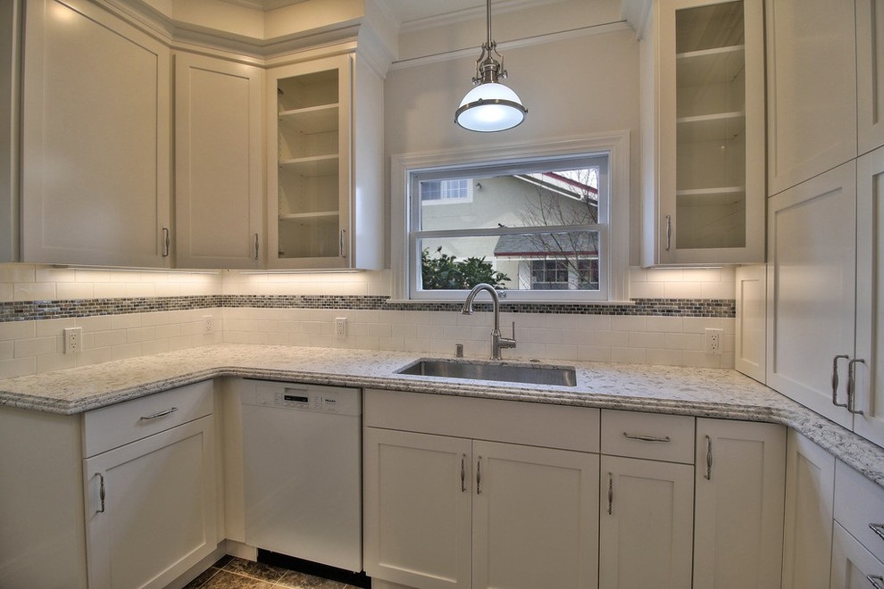 Eat-in kitchen - small transitional galley vinyl floor eat-in kitchen idea in San Francisco with an undermount sink, shaker cabinets, white cabinets, quartzite countertops, white backsplash, glass tile backsplash and stainless steel appliances