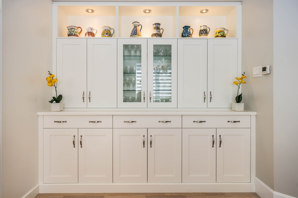 Eat-in kitchen - mid-sized transitional u-shaped light wood floor eat-in kitchen idea in Montreal with an undermount sink, shaker cabinets, white cabinets, quartzite countertops, gray backsplash, mosaic tile backsplash, stainless steel appliances and a peninsula