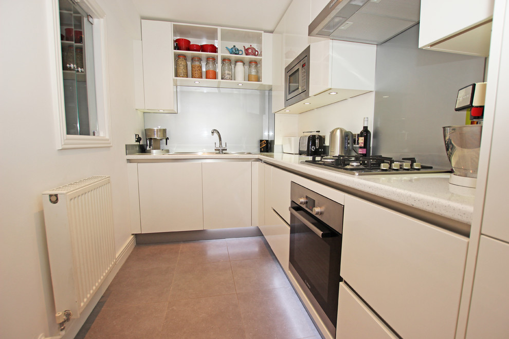 Inspiration for a small modern l-shaped kitchen in London with white cabinets and grey splashback.