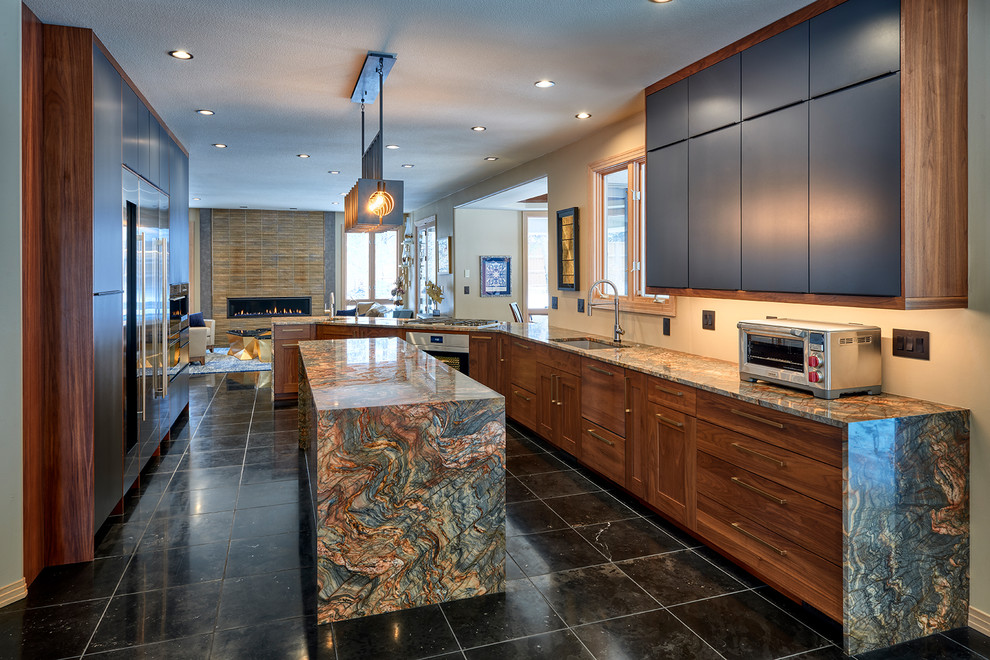 Exempel på ett mellanstort eklektiskt flerfärgad flerfärgat kök, med en undermonterad diskho, släta luckor, granitbänkskiva, rostfria vitvaror, en köksö och svart golv