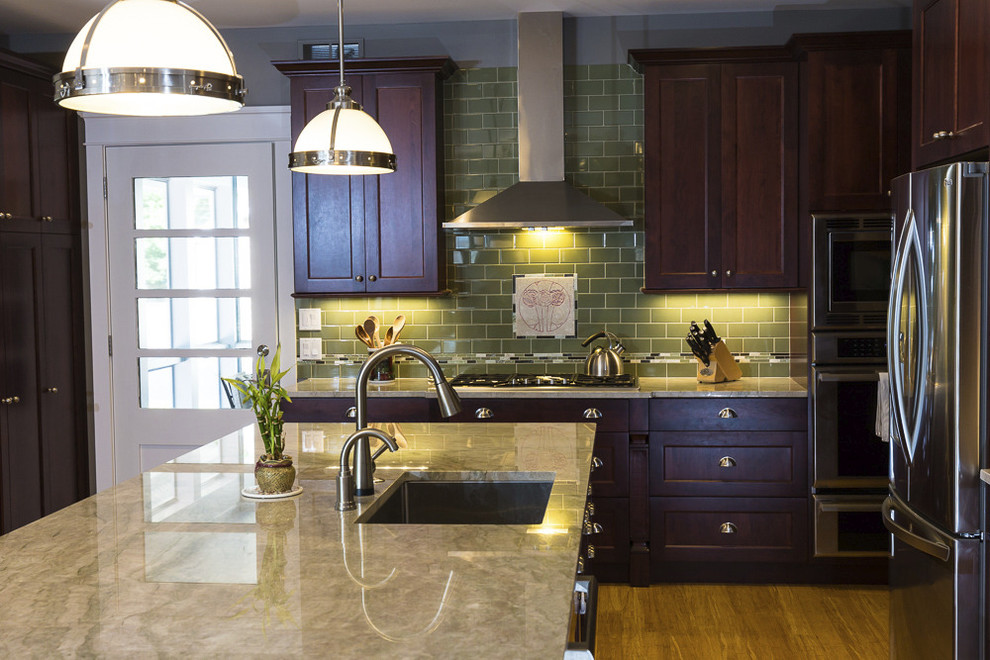 Inspiration for a mid-sized craftsman l-shaped light wood floor open concept kitchen remodel in Chicago with a single-bowl sink, flat-panel cabinets, dark wood cabinets, marble countertops, green backsplash, ceramic backsplash, stainless steel appliances and an island