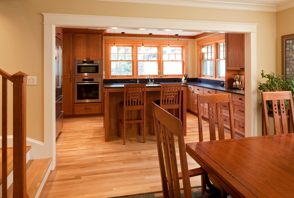 Inspiration for a large craftsman u-shaped light wood floor eat-in kitchen remodel in Portland with an undermount sink, shaker cabinets, medium tone wood cabinets, quartz countertops, stainless steel appliances and an island
