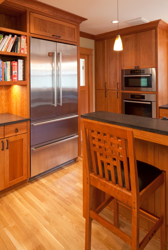 Eat-in kitchen - large craftsman light wood floor eat-in kitchen idea in Portland with shaker cabinets, medium tone wood cabinets, quartz countertops, stainless steel appliances and an island