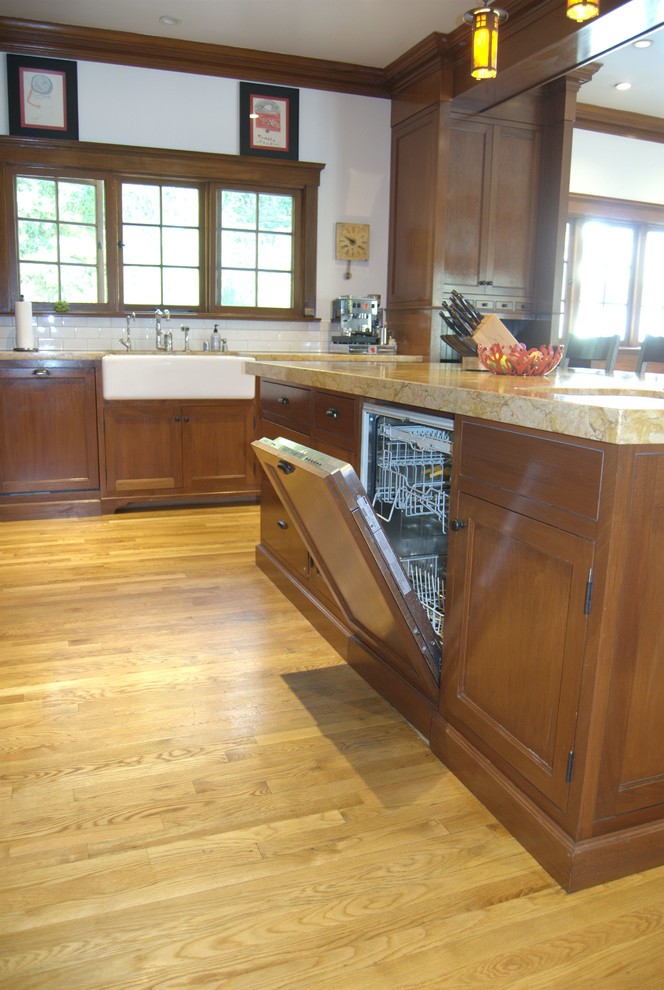 Foto på ett stort amerikanskt kök, med en rustik diskho, skåp i shakerstil, skåp i mörkt trä, granitbänkskiva, vitt stänkskydd, stänkskydd i tunnelbanekakel, rostfria vitvaror, mellanmörkt trägolv och en köksö