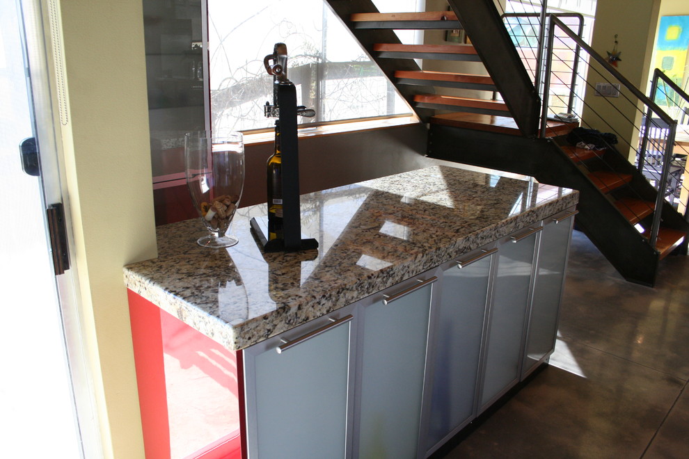 Immagine di una grande cucina design con ante di vetro, ante rosse, top in granito, pavimento in cemento e 2 o più isole