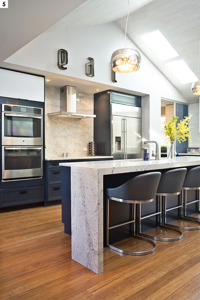 Exempel på ett stort modernt kök, med en undermonterad diskho, luckor med infälld panel, blå skåp, granitbänkskiva, grått stänkskydd, stänkskydd i sten, rostfria vitvaror, en köksö och bambugolv