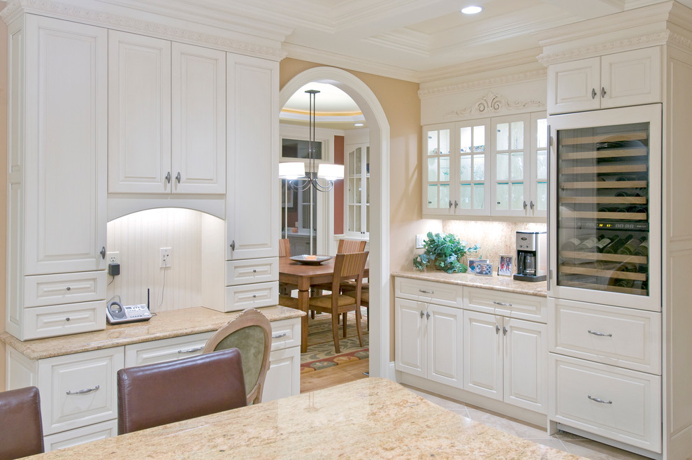 Eat-in kitchen - large traditional single-wall ceramic tile eat-in kitchen idea in Boston with an undermount sink, raised-panel cabinets, white cabinets, granite countertops, beige backsplash, ceramic backsplash and paneled appliances