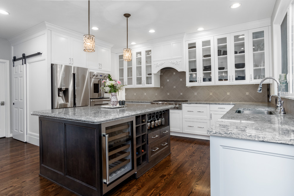 Inspiration for a large transitional u-shaped medium tone wood floor and brown floor eat-in kitchen remodel in Boise with an undermount sink, shaker cabinets, white cabinets, quartz countertops, gray backsplash, porcelain backsplash, stainless steel appliances, an island and gray countertops