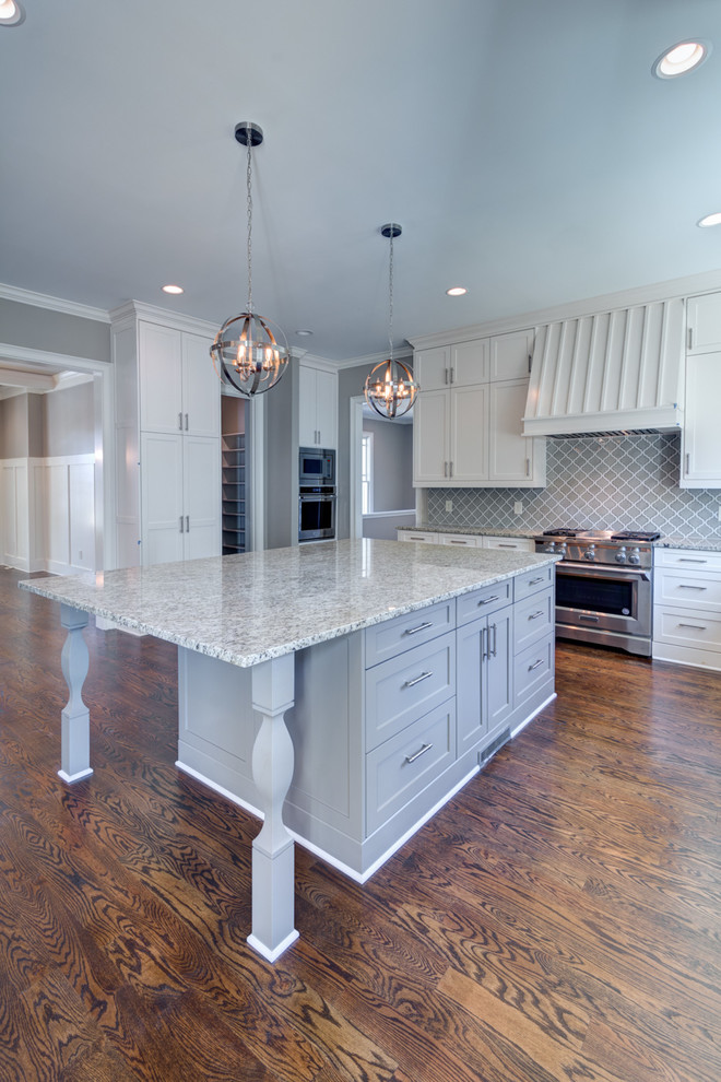 Large transitional l-shaped medium tone wood floor and brown floor eat-in kitchen photo in Atlanta with an undermount sink, shaker cabinets, white cabinets, granite countertops, gray backsplash, porcelain backsplash, stainless steel appliances and an island