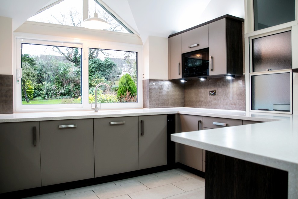 Contemporary kitchen in Hertfordshire with brown splashback and glass tiled splashback.