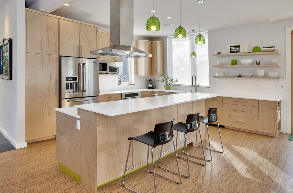 Moderne Küche in L-Form mit flächenbündigen Schrankfronten, hellen Holzschränken, Küchengeräten aus Edelstahl, hellem Holzboden und Kücheninsel in Seattle