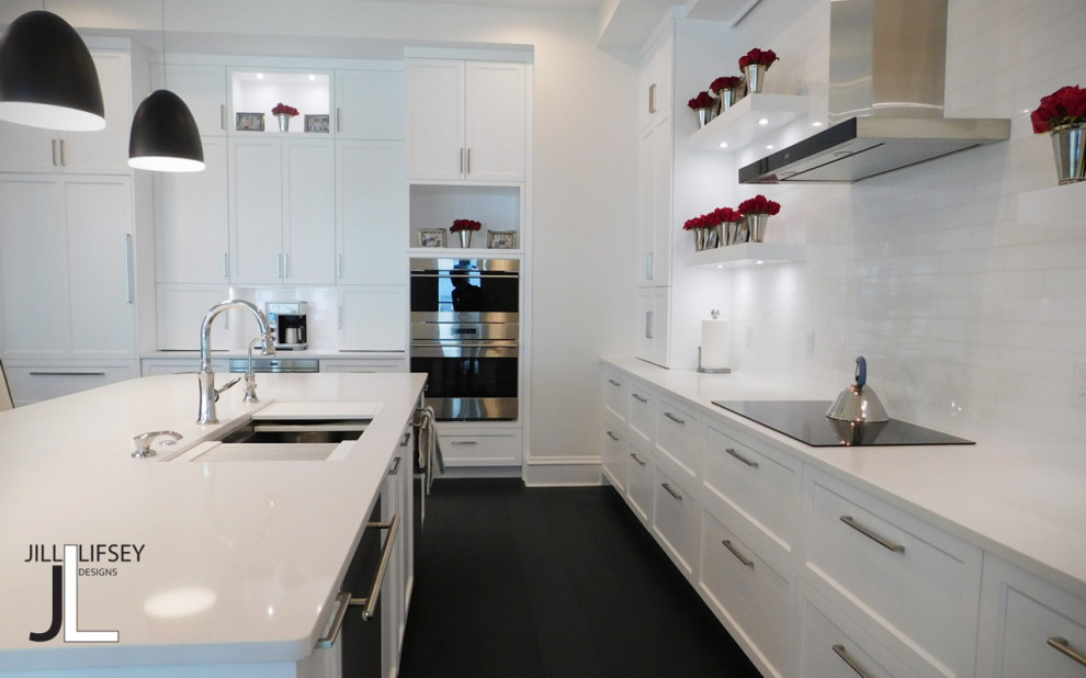 Eat-in kitchen - mid-sized modern l-shaped dark wood floor and black floor eat-in kitchen idea in Tampa with an undermount sink, shaker cabinets, white cabinets, quartzite countertops, white backsplash, subway tile backsplash, stainless steel appliances, an island and white countertops