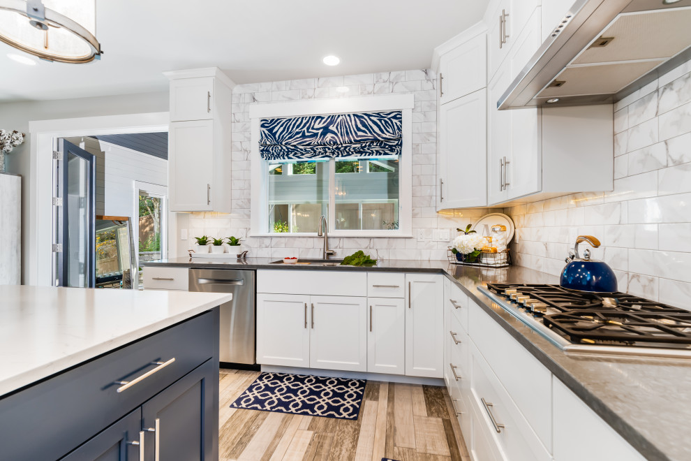 Foto på ett mellanstort amerikanskt vit kök, med en undermonterad diskho, skåp i shakerstil, vita skåp, bänkskiva i kvarts, vitt stänkskydd, stänkskydd i porslinskakel, rostfria vitvaror, klinkergolv i keramik, en köksö och grått golv