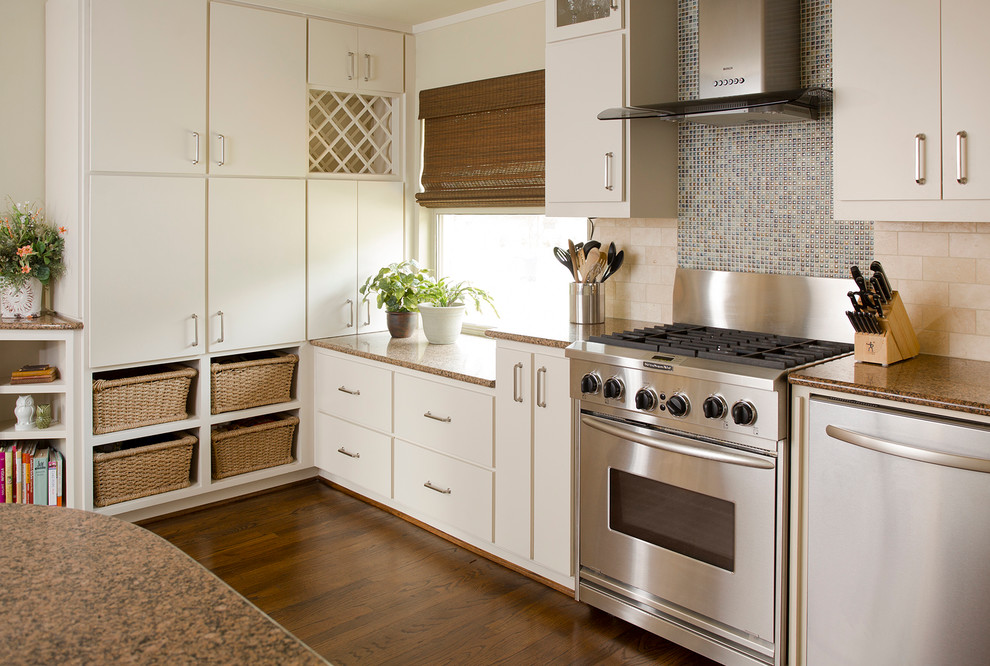 Inspiration for a timeless u-shaped medium tone wood floor kitchen remodel in Dallas with an undermount sink, flat-panel cabinets, white cabinets, granite countertops, blue backsplash, stainless steel appliances and an island
