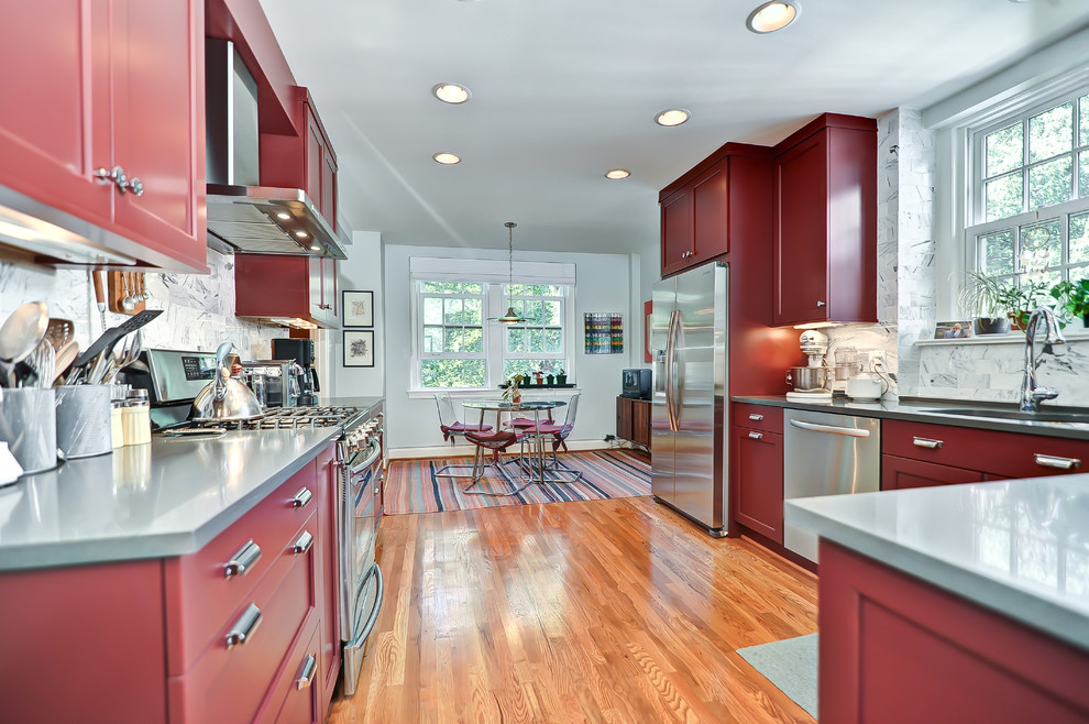 Elegant eat-in kitchen photo in DC Metro with shaker cabinets, red cabinets, white backsplash and stainless steel appliances
