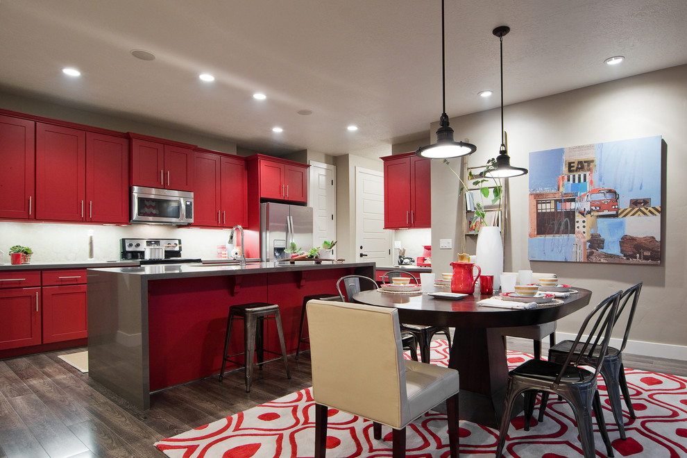 Contemporary single-wall kitchen/diner in Salt Lake City with red cabinets, a submerged sink, shaker cabinets, quartz worktops, stainless steel appliances, medium hardwood flooring and an island.