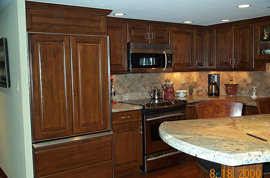 Idéer för att renovera ett litet vintage kök, med en undermonterad diskho, luckor med upphöjd panel, skåp i mellenmörkt trä, granitbänkskiva, beige stänkskydd, stänkskydd i stenkakel, integrerade vitvaror, mellanmörkt trägolv och en köksö