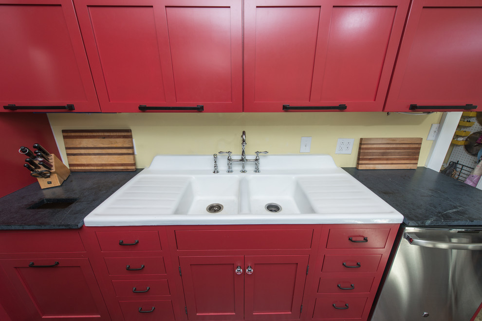 Medium sized contemporary galley kitchen/diner in Other with a double-bowl sink, raised-panel cabinets, red cabinets, soapstone worktops, stainless steel appliances, dark hardwood flooring, an island and brown floors.