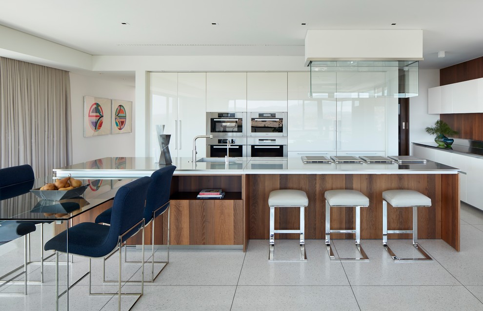 Moderne Küchenbar mit flächenbündigen Schrankfronten, weißen Schränken, Küchengeräten aus Edelstahl und zwei Kücheninseln in Orange County